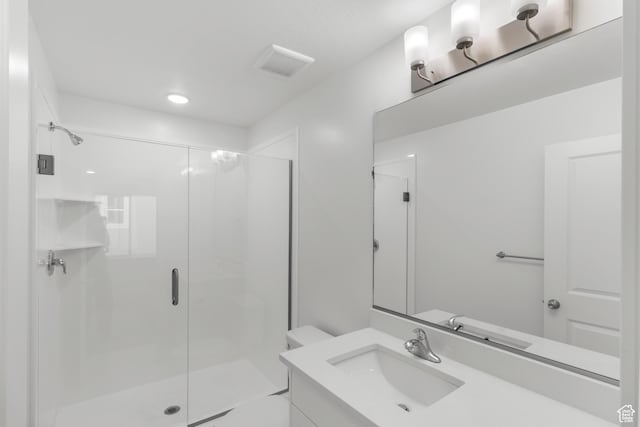 bathroom featuring a stall shower, vanity, and toilet