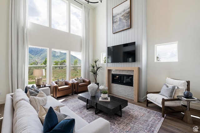 1015 W Sugar Maple Dr, Mapleton, UT 84664 - living room with a high ceiling, a glass covered fireplace, healthy amount of natural light, wood finished floors, and baseboards