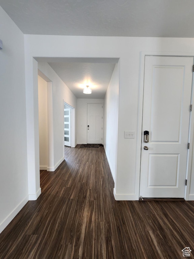 hallway with baseboards and dark wood finished floors