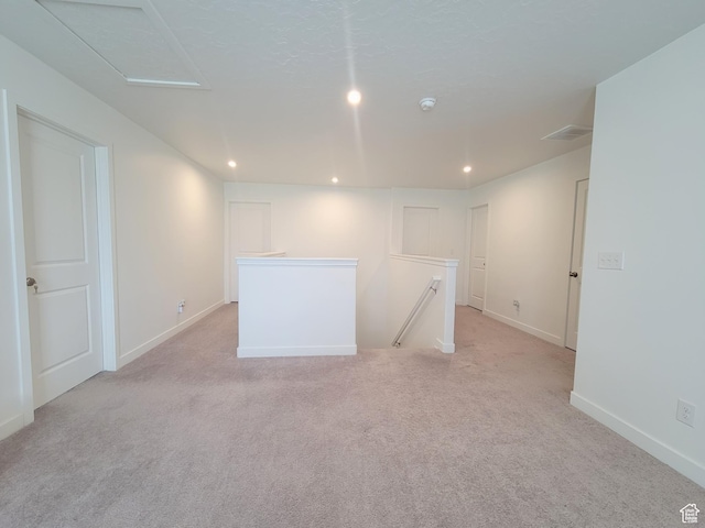 empty room featuring recessed lighting, light carpet, and baseboards