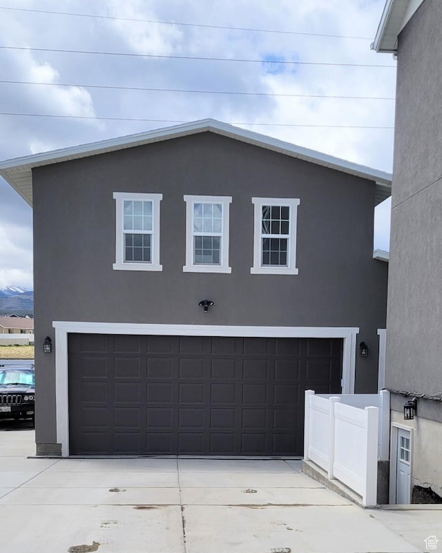 view of front of property with a garage, stucco siding, and driveway