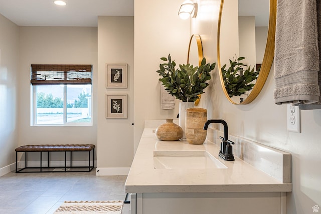 bathroom featuring double vanity, tile patterned flooring, baseboards, and recessed lighting