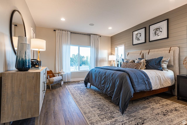 bedroom featuring dark wood-style flooring, wood walls, recessed lighting, and baseboards