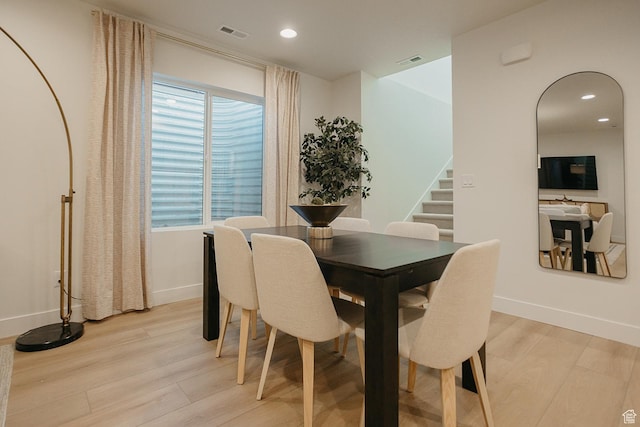 dining room with light wood-type flooring, stairs, recessed lighting, and baseboards