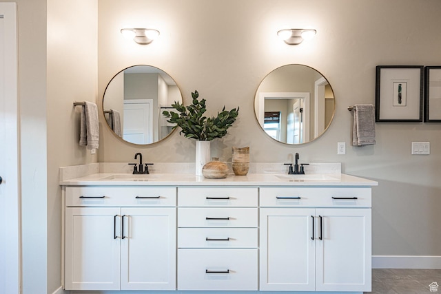 full bathroom with double vanity and baseboards