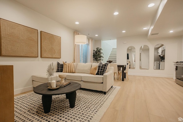 living area with stairway, recessed lighting, light wood finished floors, and baseboards