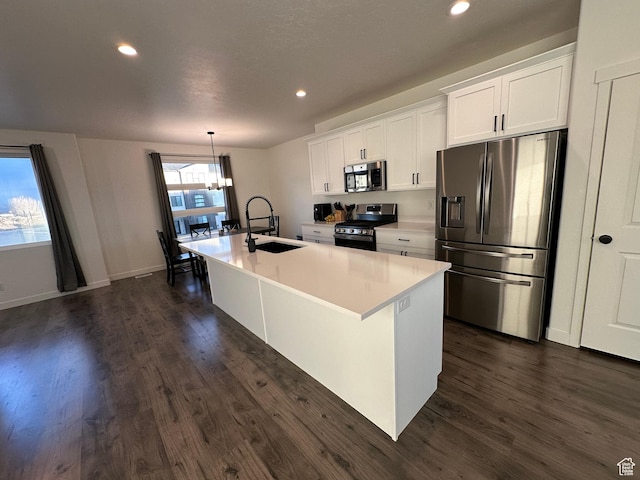 568 S 900 W, American Fork, UT 84003 - kitchen with appliances with stainless steel finishes, a sink, a kitchen island with sink, dark wood-style floors, and white cabinetry