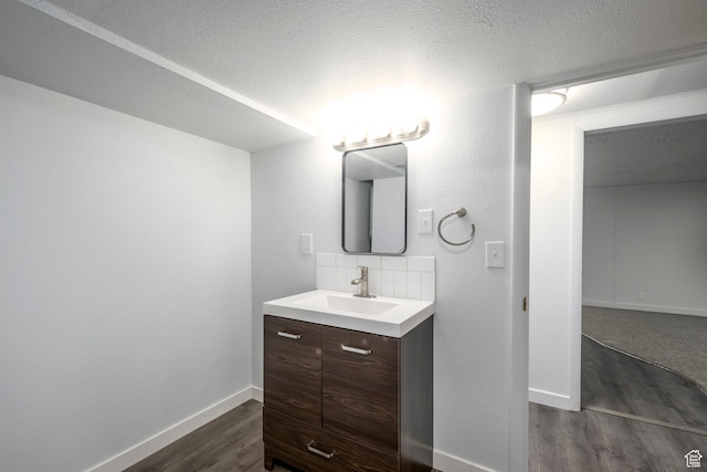 547 N 650 E, Orem, UT 84097 - bathroom featuring wood finished floors, vanity, baseboards, decorative backsplash, and a textured ceiling