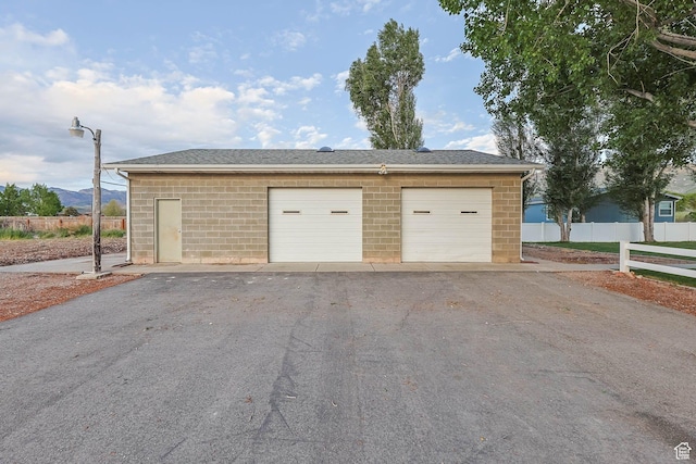 detached garage featuring fence