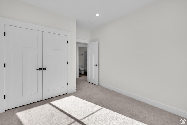 unfurnished bedroom featuring carpet floors, baseboards, a closet, and recessed lighting