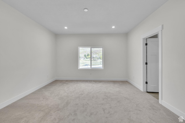 carpeted spare room featuring baseboards and recessed lighting
