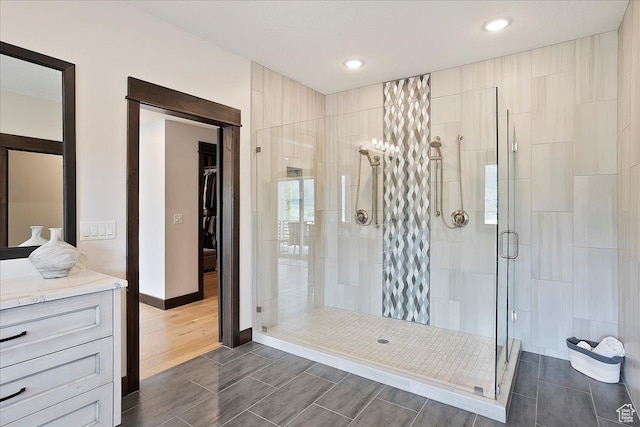 3749 N Eagle Ridge Dr E, Eden, UT 84310 - bathroom featuring a stall shower, wood finish floors, baseboards, recessed lighting, and vanity