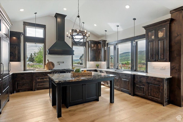 3749 N Eagle Ridge Dr E, Eden, UT 84310 - kitchen featuring a sink, premium range hood, dark stone counters, hanging light fixtures, and recessed lighting