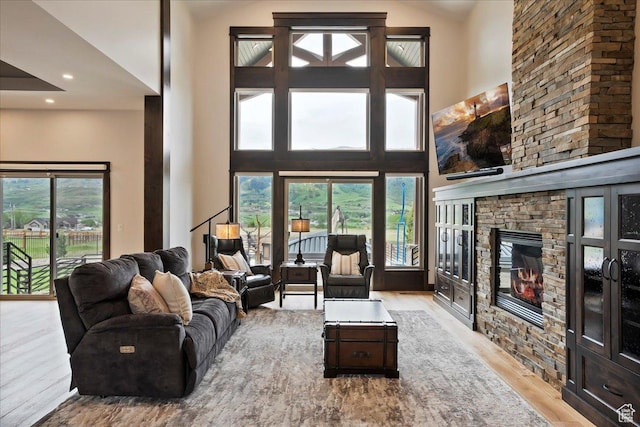 3749 N Eagle Ridge Dr E, Eden, UT 84310 - living room featuring wood finished floors, a stone fireplace, a high ceiling, and recessed lighting