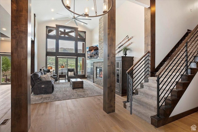 3749 N Eagle Ridge Dr E, Eden, UT 84310 - living room featuring hardwood / wood-style flooring, a fireplace, high vaulted ceiling, stairs, and a chandelier