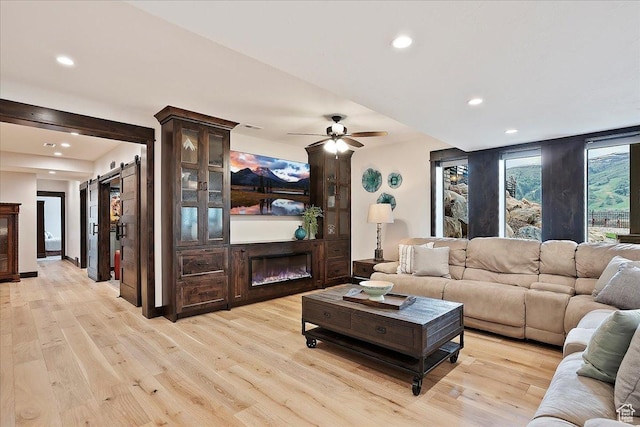 3749 N Eagle Ridge Dr E, Eden, UT 84310 - living room featuring recessed lighting, light wood-style flooring, a barn door, and a ceiling fan