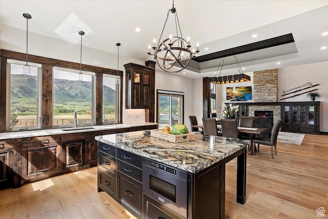 3749 N Eagle Ridge Dr E, Eden, UT 84310 - kitchen with a sink, a tray ceiling, a chandelier, light wood-type flooring, and hanging light fixtures