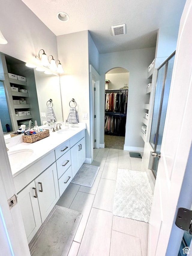 3146 W 1280 N, Provo, UT 84601 - bathroom featuring a shower stall, double vanity, a spacious closet, a textured ceiling, and baseboards