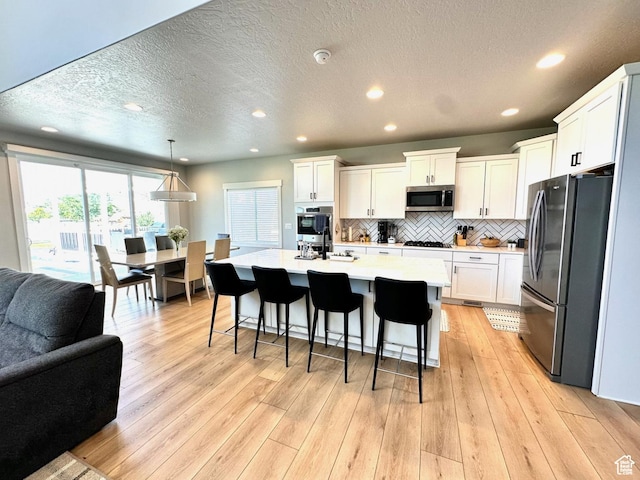 3146 W 1280 N, Provo, UT 84601 - kitchen with stainless steel appliances, open floor plan, light countertops, white cabinetry, and a breakfast bar