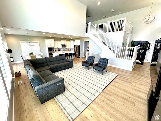 3146 W 1280 N, Provo, UT 84601 - living room featuring a towering ceiling, light wood-type flooring, stairway, baseboards, and arched walkways