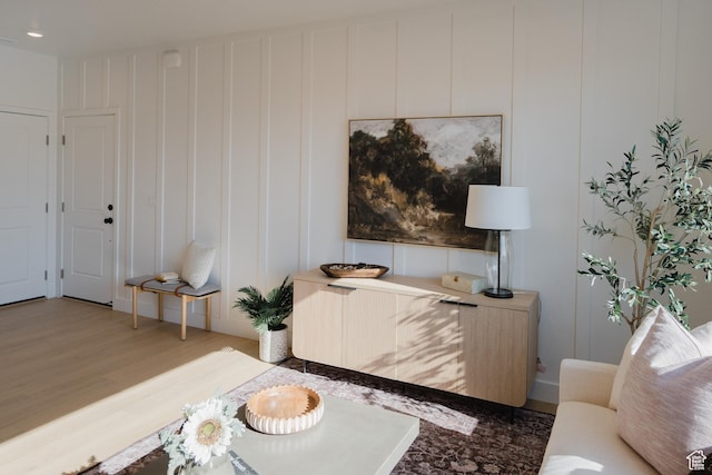 living room with a decorative wall, wood finished floors, and recessed lighting