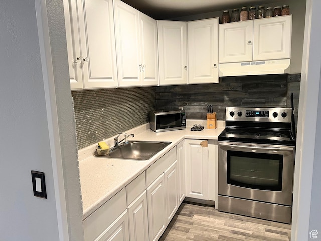 3272 W 3540 S Unit A-B, West Valley City, UT 84119 - kitchen with electric stove, under cabinet range hood, a sink, decorative backsplash, and light countertops