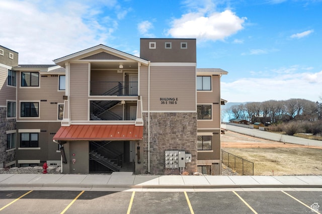 view of building exterior with uncovered parking and stairs