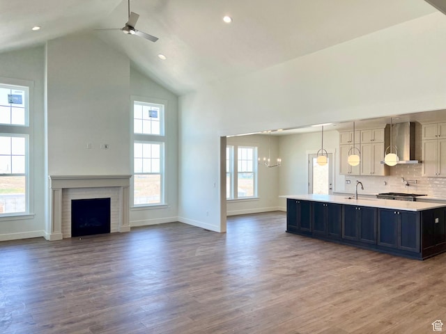 11121 S Bingham Rim Rd W Unit 5-425, South Jordan, UT 84009 - kitchen featuring high vaulted ceiling, wall chimney range hood, light countertops, an island with sink, and open floor plan