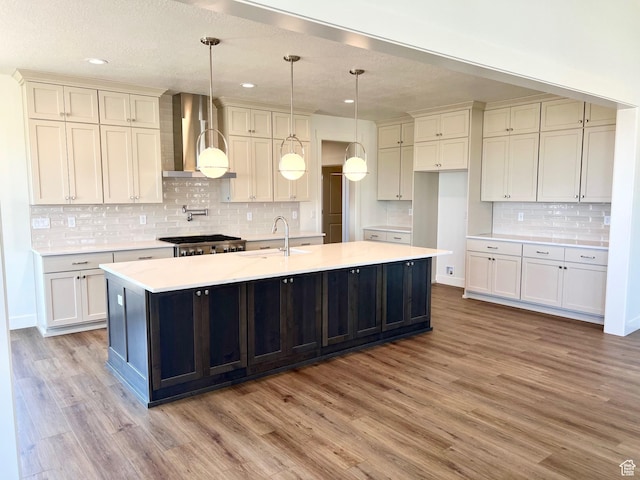 11121 S Bingham Rim Rd W Unit 5-425, South Jordan, UT 84009 - kitchen featuring wall chimney exhaust hood, wood finished floors, a large island, decorative backsplash, and recessed lighting