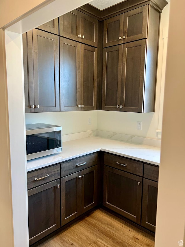 11121 S Bingham Rim Rd W Unit 5-425, South Jordan, UT 84009 - kitchen featuring stainless steel microwave, dark brown cabinetry, and light wood-type flooring