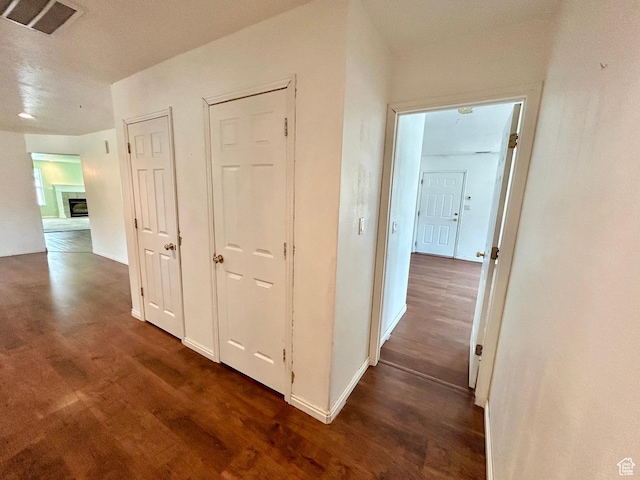 corridor with dark wood-style floors and baseboards