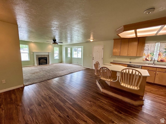 kitchen featuring light countertops, ceiling fan, dishwasher, baseboards, and a textured ceiling