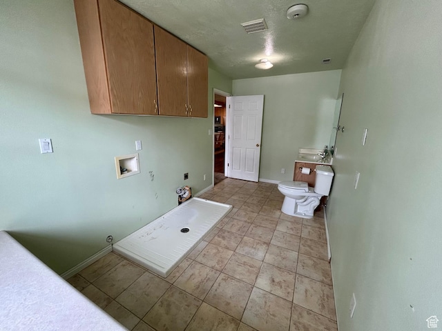 laundry room featuring washer hookup, baseboards, and light tile patterned flooring