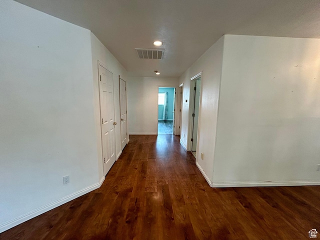 hallway with wood finished floors, baseboards, and recessed lighting