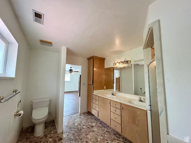 full bathroom featuring healthy amount of natural light, toilet, double vanity, and baseboards