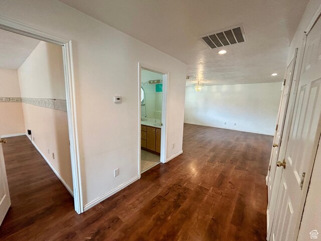 corridor with recessed lighting, wood finished floors, and baseboards