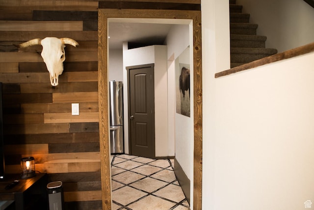 hallway featuring wood walls and light tile patterned flooring