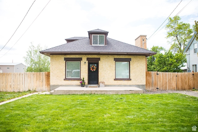 bungalow-style house featuring brick siding, a shingled roof, a chimney, and covered porch