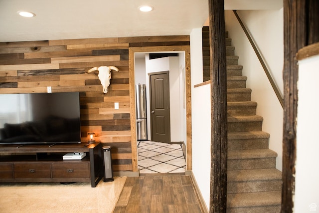 staircase with wood walls and recessed lighting