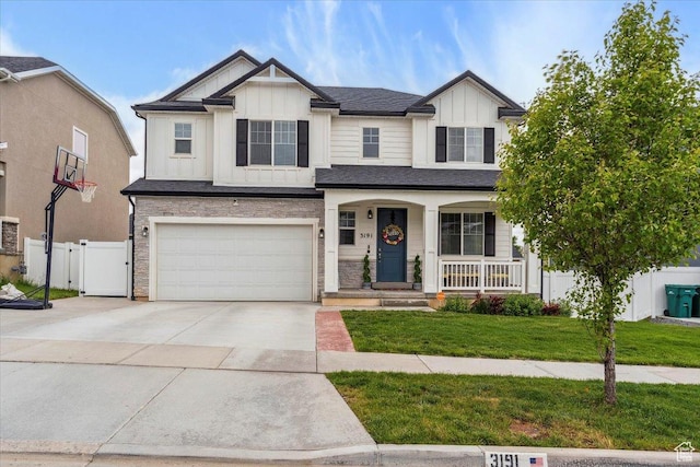 3191 N 1500 E, Layton, UT 84040 - view of front facade with board and batten siding, a porch, a garage, driveway, and a gate