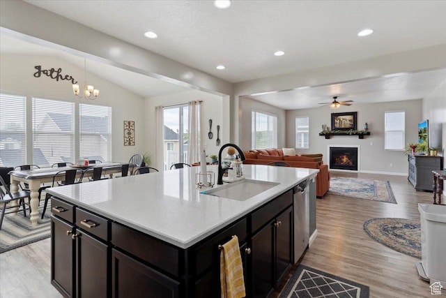 3191 N 1500 E, Layton, UT 84040 - kitchen with a sink, a lit fireplace, light wood-type flooring, vaulted ceiling, and light countertops
