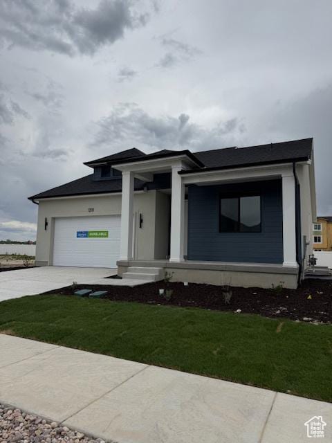 view of front of house with a front yard, a garage, and concrete driveway