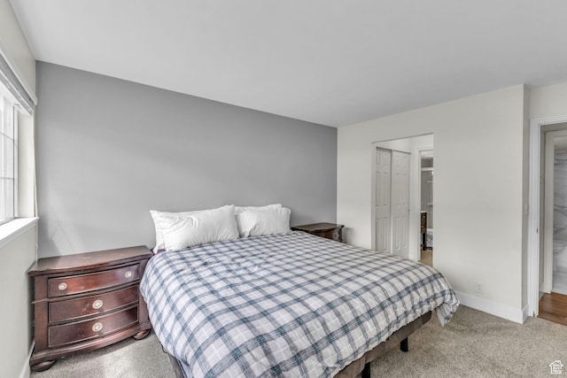 carpeted bedroom with baseboards and a closet