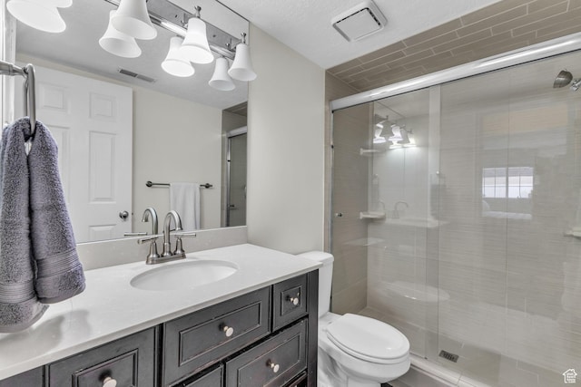 full bathroom featuring toilet, a stall shower, and vanity