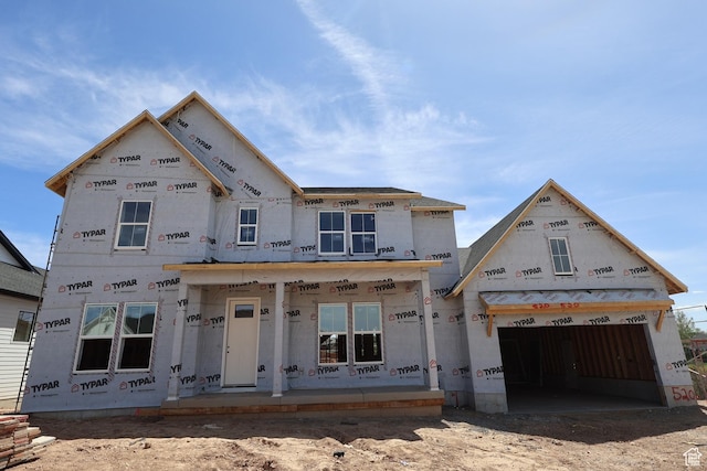 property under construction with covered porch and a garage