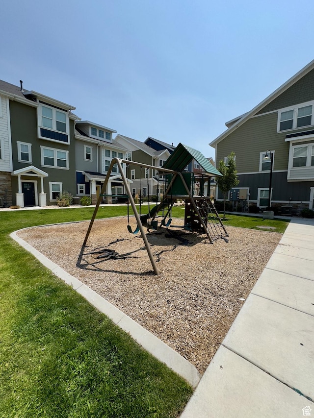 community playground with a residential view and a lawn