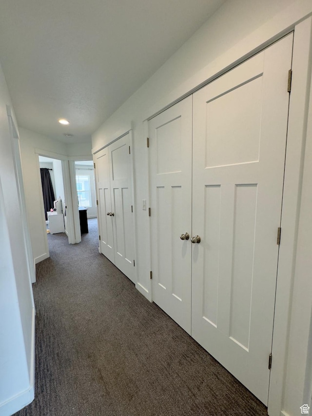 hall featuring dark colored carpet, baseboards, and recessed lighting
