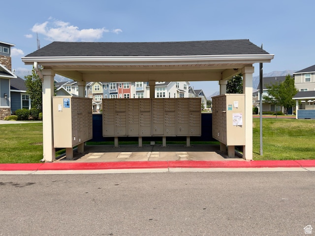 surrounding community with mail area and a yard