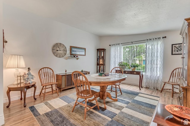 3238 S Maple Way, West Valley City, UT 84119 - dining space featuring light wood finished floors, a textured ceiling, and baseboards