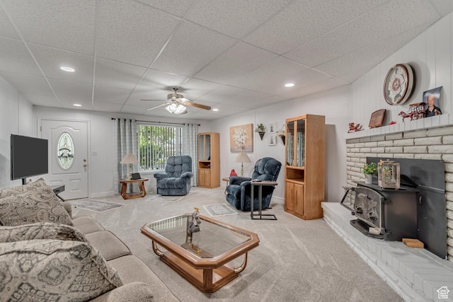 3238 S Maple Way, West Valley City, UT 84119 - living area featuring a ceiling fan, light carpet, a paneled ceiling, a wood stove, and recessed lighting